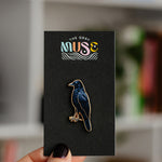 American crow enamel pin with a dark blue body on a black display card