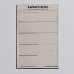 Single beige Awareness notepad with bold title at top and blank sections wrapped with a band