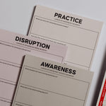 Pastel trio of plain notepads labeled Practice Disruption Awareness for personal growth.