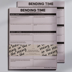 Two pink Bending Time Notepad booklets stacked with bold BENDING TIME title and grid prompts for reflection