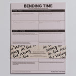 Bending Time Notepad with pale pink cover, four quadrant prompts, and a decorative wraparound band.