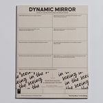 Dynamic Mirror Notepad cropped on a light background with visible grid prompts and decorative bottom packaging