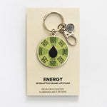 Beige card for Energy Spinner Interactive Enamel Keychain with a green segmented wheel, black center, and small charm.