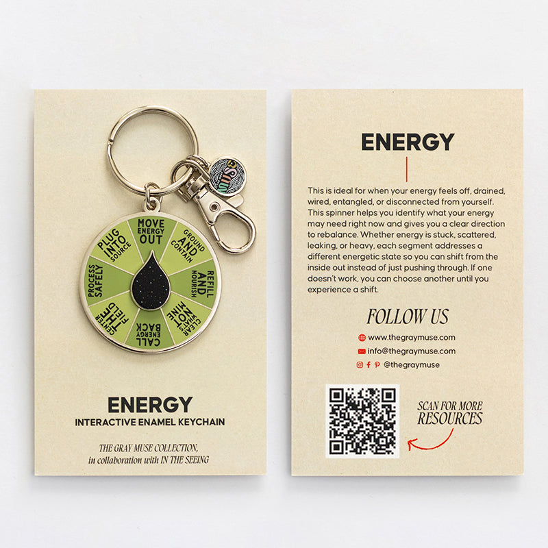 Energy Spinner interactive enamel keychain with a green segmented wheel and black drop center on a beige display card