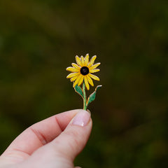 Yellow Black-Eyed Susan enamel pin Maryland state flower held between fingers