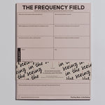 The Frequency Field Notepad pink page with a grid of prompts for emotional awareness and a wraparound band
