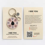 I See You spinner enamel keychain with pink segmented wheel and black center on a beige display card.