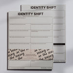 Identity Shift notepads stacked with bold header and grid prompts for personal transformation.