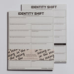 Identity Shift Notepad with bold title and a two column grid of prompts on white sheets wrapped by a decorative band