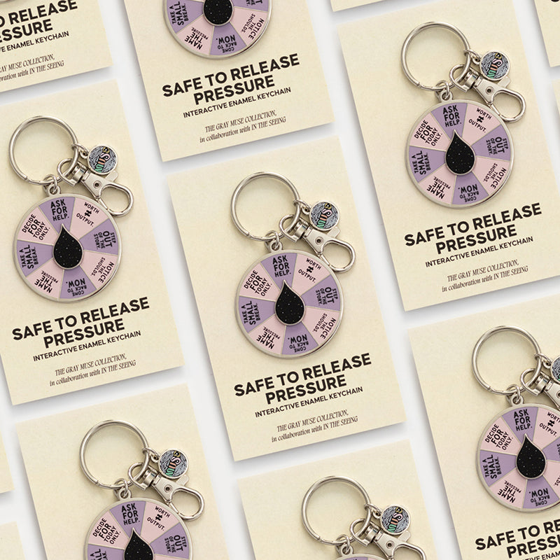 Promotional card displays Safe to Release Pressure enamel keychain with a purple segmented spinner and silver ring