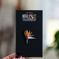 Bird of Paradise enamel pin displayed on a black card with The Gray Muse logo