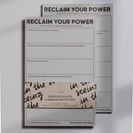 Reclaim Your Power notepad stack with bold title on the top sheet and a decorative wraparound band visible.