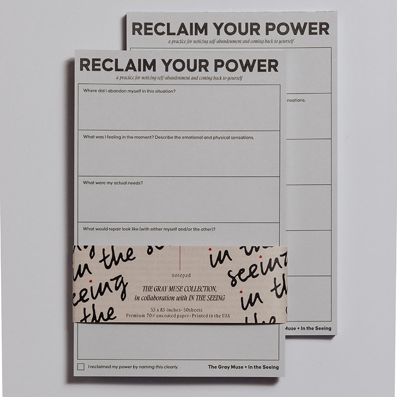 Two Reclaim Your Power notepads stacked with a beige wrap featuring black handwritten script around the lower portion.