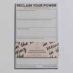 Reclaim Your Power Notepad partially wrapped in a decorative band with branding visible.