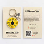 Front and back packaging for Reclamation enamel keychain showing the front card with the keychain and the back card with description and a QR code