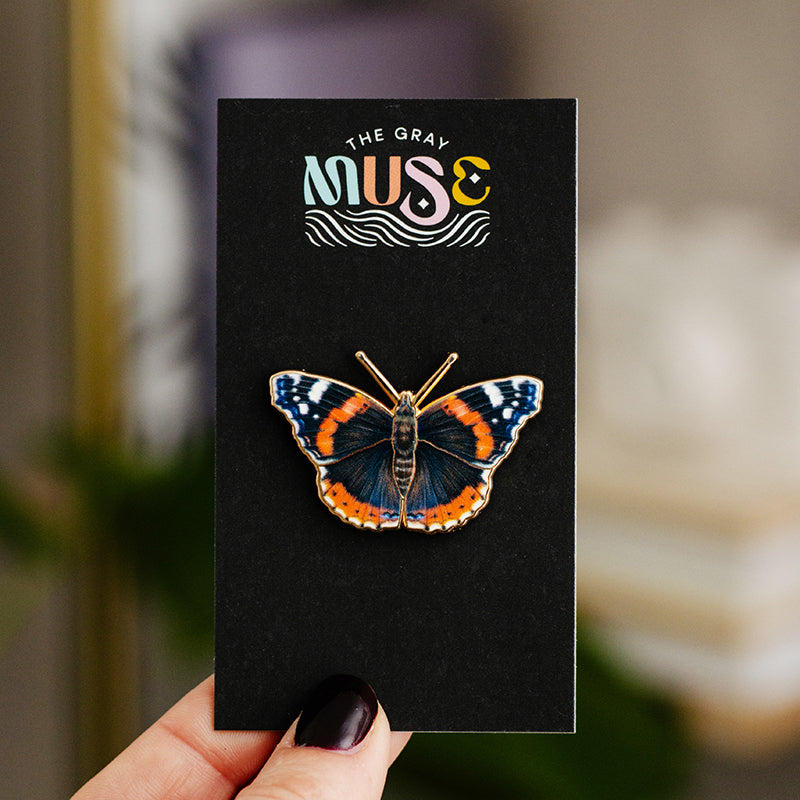 Red Admiral butterfly enamel pin mounted on a black display card with The Gray Muse branding