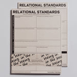 Relational Standards Notepad with bold title and grid prompts, shown with a decorative sleeve.