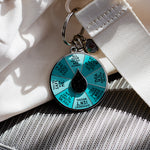 Reparenting Spinner Interactive Enamel Keychain with teal prompt wheel and black center drop on a metal ring.