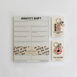 Safe to be Seen Bundle with Identity Shift Notepad and two enamel keychains The Expansion Edge and Safe to Be Seen on a clean desk.