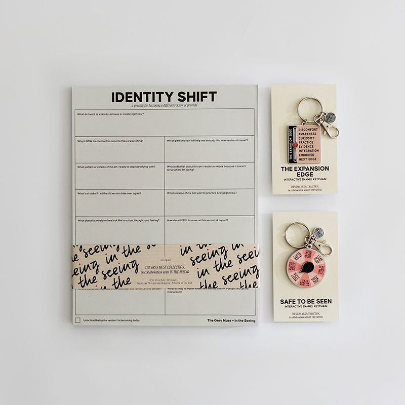Safe to be Seen Bundle with Identity Shift Notepad and two enamel keychains The Expansion Edge and Safe to Be Seen on a clean desk.