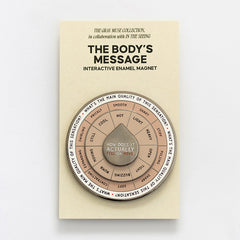 The Body's Message interactive enamel magnet with a circular segmented spinner on beige packaging.