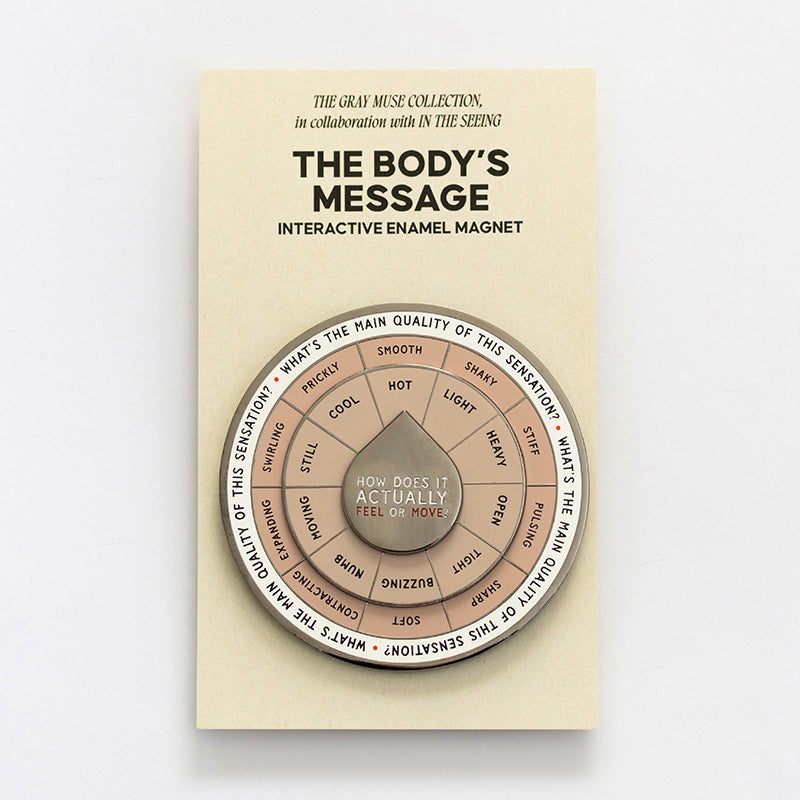The Body's Message interactive enamel magnet with a circular segmented spinner on beige packaging.
