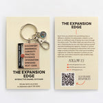 Beige display card featuring The Expansion Edge interactive enamel keychain with stacked enamel panels and a small spiral charm.