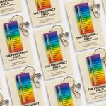 Product display of The Frequency Field enamel keychains on cream cards.