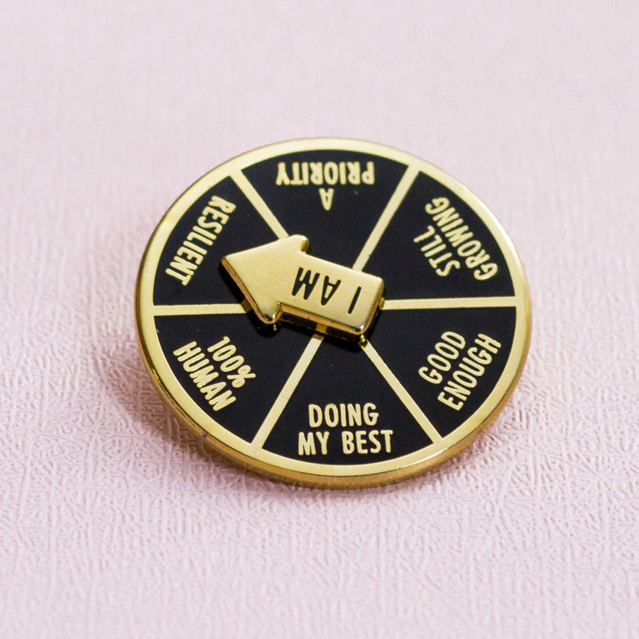 Gold edged circular spinner enamel pin